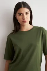 Remera de corte oversized, color verde oliva, con cuello redondo y mangas cortas.