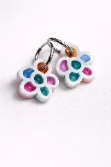 Par de aros colgantes con forma de flor, con pétalos de acrílico de colores translúcidos (naranja, verde azulado, fucsia, lila y celeste) y argollas de metal plateado.