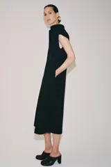 Vestido midi camisero de algodón color negro, con cuello solapa, sin mangas y cierre frontal con botones ocultos por solapa. Incluye cintura ajustable con tiras de lazada lateral en el mismo tejido.