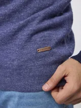 Sweater de tejido de punto color tostado, con cuello alto y cierre frontal parcial. Presenta mangas largas con puños acanalados y un diseño de corte clásico.