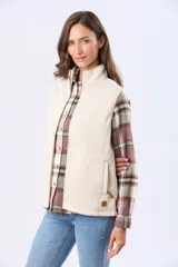 Chaleco de cuello alto con cierre frontal completo, confeccionado en tejido tipo polar. Presenta dos bolsillos laterales con cierre y un pequeño parche decorativo en la parte inferior.