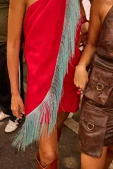 Minivestido rojo de lino con escote halter, espalda descubierta y detalle de flecos celestes en el ruedo.