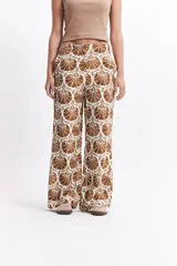 Pantalón wide leg estampado con diseño de conchas marinas en tonos verde oscuro y blanco. Presenta un calce relajado y cintura media.