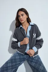 Campera de punto tipo cardigan en color bordó, con cierre frontal, cuello redondo y diseño estilo universitario. Presenta el número 54 bordado en blanco en el pecho y franjas blancas en las mangas.