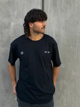 Remera negra oversize con cuello redondo y estampado pequeño en el pecho.