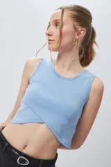 Top cropped sin mangas, color celeste claro, con escote redondo y cruce asimétrico en el bajo.