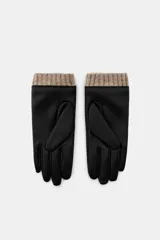 Guantes cortos combinados en efecto piel color negro, con puños de lana en color marrón y detalle de botón a presión.