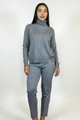 Polera de cuello alto y manga larga, confeccionada en tejido de punto de algodón con textura sutil. Presenta un corte recto con aberturas laterales en el ruedo.