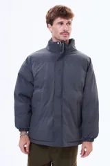 Campera puffer negra de corte estándar, con cuello alto, cierre frontal completo y puños elásticos.