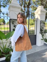 Bolso tipo tote bag color camel, confeccionado en cuero gamuzado.