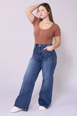 Pantalón de jean azul oscuro, corte wide leg, tiro alto y detalle de bolsillos frontales con costuras a la vista.