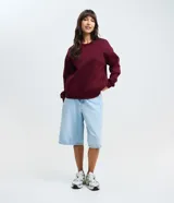 Buzo femenino de cuello redondo y manga larga, confeccionado en tejido de algodón con felpa. Presenta un diseño básico sin estampado, con puños y ruedo ajustados en tejido rib.