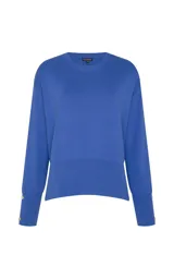 Sweater de punto color azul, de corte recto y ligero estilo holgado, con cuello redondo, mangas largas con puños ajustados por botones metálicos y dobladillo acanalado.