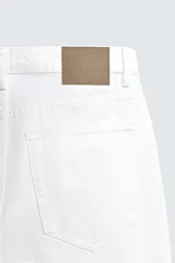 Jeans de corte recto desde la cadera hasta el tobillo, con tiro medio y confeccionados en denim de algodón rígido. Presentan diseño clásico de cinco bolsillos y cierre frontal con botones.