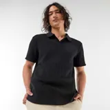 Remera de punto calado negro, de manga corta, con cuello polo y diseño texturizado.