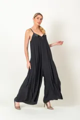 Enterito de viscosa color negro, con diseño holgado y piernas anchas. Presenta escote en V con detalle de satén y breteles finos.