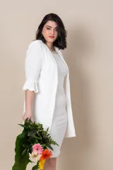 Vestido blanco con bordado de perlas y canutillos en el escote y túnica larga con tajos y ribete de satén.