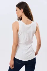 Musculosa de algodón color beige con delicado estampado floreado, escote redondo y pequeños volados en las sisas.