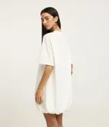 Vestido estilo camiseta de algodón, con cuello redondo, mangas cortas y diseño oversized con efecto balonê en el ruedo.