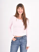 Remera de manga larga en color rosado, con cuello redondo y ajuste al cuerpo.