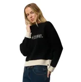 Buzo tejido de punto Rip Curl Archive modelo Script Knit, color negro con detalles en color crudo en el cuello, puños y dobladillo inferior. Presenta el nombre de la marca bordado en el pecho.