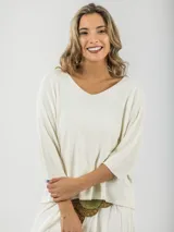 Sweater tejido fino italiano color crudo, con escote en V y mangas 3/4. Diseño holgado y liviano.