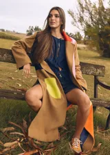 Tapado largo color camel con cuello solapa y diseño de bloques de color en tonos vibrantes como rojo, rosa, amarillo, naranja y azul.