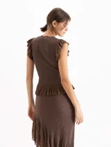 Top marrón de punto plisado con escote redondo, sin mangas y detalles de volados en sisas y en el ruedo con acabado peplum.