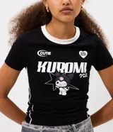 Remera de algodón con elastano, corte ajustado, cuello redondo y mangas cortas. Presenta un diseño en color negro con cuello blanco y vivos laterales blancos. Incluye estampa frontal del personaje Kuromi con detalles gráficos y texto.