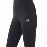 Calza deportiva New Balance de tiro alto, color negro, con logo de la marca en el muslo y estampado vertical en la pierna.