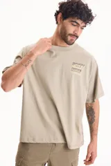 Remera oversize verde de manga corta y cuello redondo, con pequeño estampado gráfico en el pecho con la inscripción "Sixty Nine".