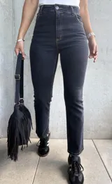 Jean negro de corte recto con lycra, tiro medio y largo a los tobillos.