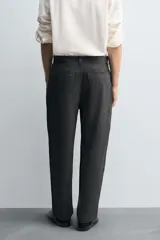 Pantalón de corte carrot fit confeccionado en tejido con mezcla de viscosa. Presenta bolsillos frontales, bolsillos traseros de vivo y cierre frontal con cremallera y botones.