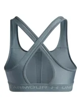 Top deportivo Under Armour de soporte medio, confeccionado en tejido HeatGear de doble capa. Presenta diseño de espalda cruzada, banda elástica inferior con logo de la marca y copas extraíbles con perforaciones para mayor transpirabilidad.