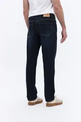 Jean de corte recto y tiro medio con efecto lavado, confeccionado en tejido de algodón con spandex. Cuenta con cierre frontal, botón y pasacintos.