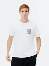Camiseta blanca de manga corta con cuello redondo y un pequeño estampado tipográfico en el pecho izquierdo que dice "simple choices greater lasting impact".