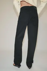 Jeans de tiro medio color negro, de corte recto y largo completo, con diseño clásico de cinco bolsillos, trabillas para cinto y cierre frontal con cremallera y botón.