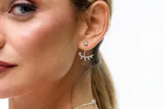 Caravanas de plata 925 con diseño de doble pieza, compuesto por un punto de luz superior y una pieza inferior con forma de pestañas decorada con circonias.