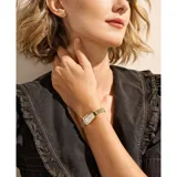 Reloj de pulsera Skagen con caja rectangular de acero inoxidable en tono dorado y esfera blanca minimalista. Incluye una malla de acero tipo milanesa y un par de aros a juego con diseño de nudo.