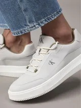 Zapatillas urbanas Calvin Klein con capellada de nailon ripstop reciclado en color gris claro. Presentan suela chunky de TPR, cordones técnicos y el monograma 'ck' distintivo en el lateral.