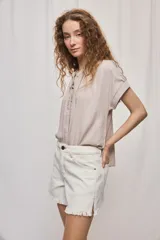 Short de jean blanco de tiro medio con silueta relajada y detalle de ruedo desflecado con flecos.