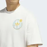 Remera de corte holgado con cuello redondo, color blanco, con un pequeño logo circular estampado en el pecho que combina el emblema de Adidas con motivos de básquetbol.