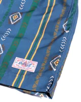 Short de baño azul con estampado geométrico en tonos marrón, verde y amarillo. Tiene cintura elástica con cordón ajustable.