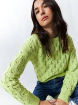 Sweater color crema tramado de manga larga y cuello redondo.