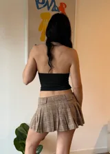 Minifalda plisada de tiro bajo con estampado de cuadros en tonos marrones y beige.