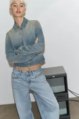 Chaqueta de denim con efecto lavado, cuello solapa, manga larga y cierre frontal con cremallera metálica.