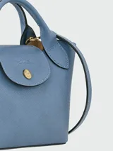 Cartera tipo shopper tamaño XS de la línea Épure de Longchamp, confeccionada en cuero de color verde menta. Presenta una estructura rígida, asas cortas superiores y un cierre de solapa con botón a presión metálico dorado.