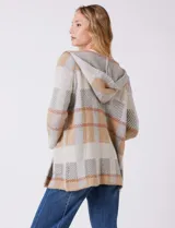 Cardigan abierto sin cierre, con capucha, de tejido de punto con diseño de bloques de color en tonos neutros como gris, beige y rosado pálido. Presenta bolsillos aplicados en la parte delantera.