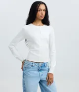 Cardigan de punto color blanco, con cuello redondo, mangas largas y cierre frontal de botones.