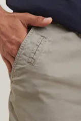Bermuda de gabardina en color verde claro, con corte recto, bolsillos laterales y cierre frontal con botón y cremallera.